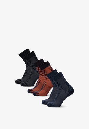 Set di quattro paia di calzini crew in nero, grigio scuro, arancione bruciato e blu navy, con una texture a costine e rinforzi nelle zone del tallone e della punta.