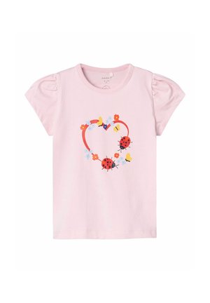 Maglietta di cotone rosa con maniche a sbuffo. Presenta un design a forma di cuore composto da coccinelle, fiori e farfalle in colori vivaci.