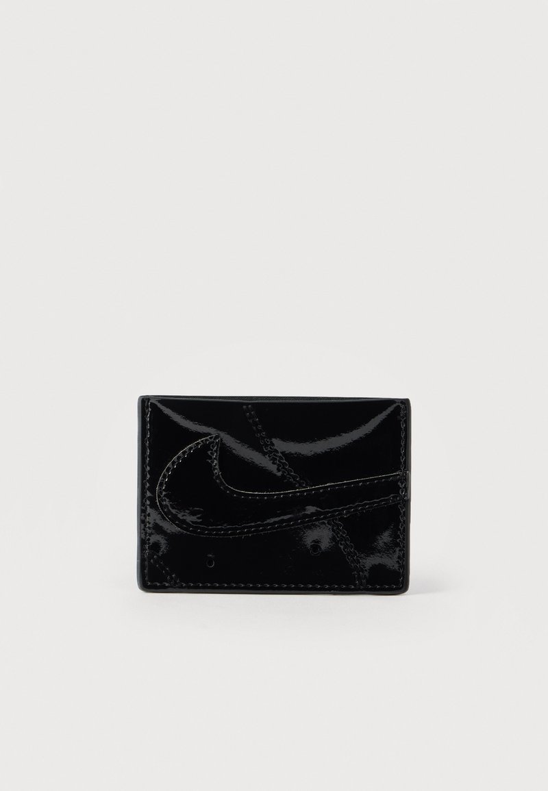 Μαύρος κάτοχος καρτών από δέρμα με γυαλιστερή επένδυση, με ανάγλυφο λογότυπο Nike, καθαρό σχέδιο και αντίθετη ραφή. Συμπαγές ορθογώνιο σχήμα.