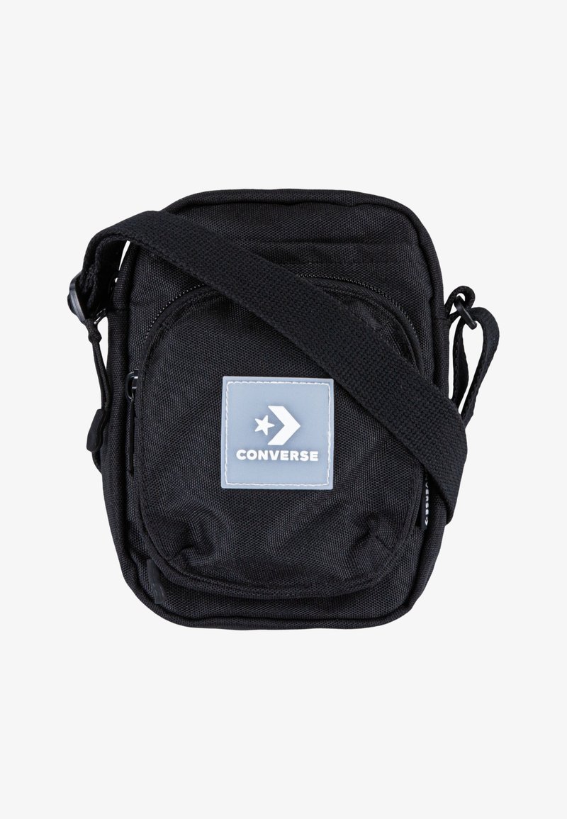 Borsa a tracolla nera con cinturino regolabile, tasca frontale con zip e patch in gomma grigio con design a stella e freccia. Materiale resistente.