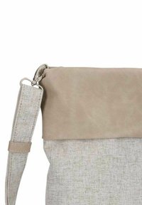 Borsa a tracolla in tessuto beige con patta liscia in similpelle e corpo intrecciato dalla texture. Include una tracolla staccabile e componenti metallici.