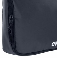 Borsa nera con cerniera dalla superficie testurizzata, con un logo bianco prominente, cerniera liscia e angoli arrotondati.