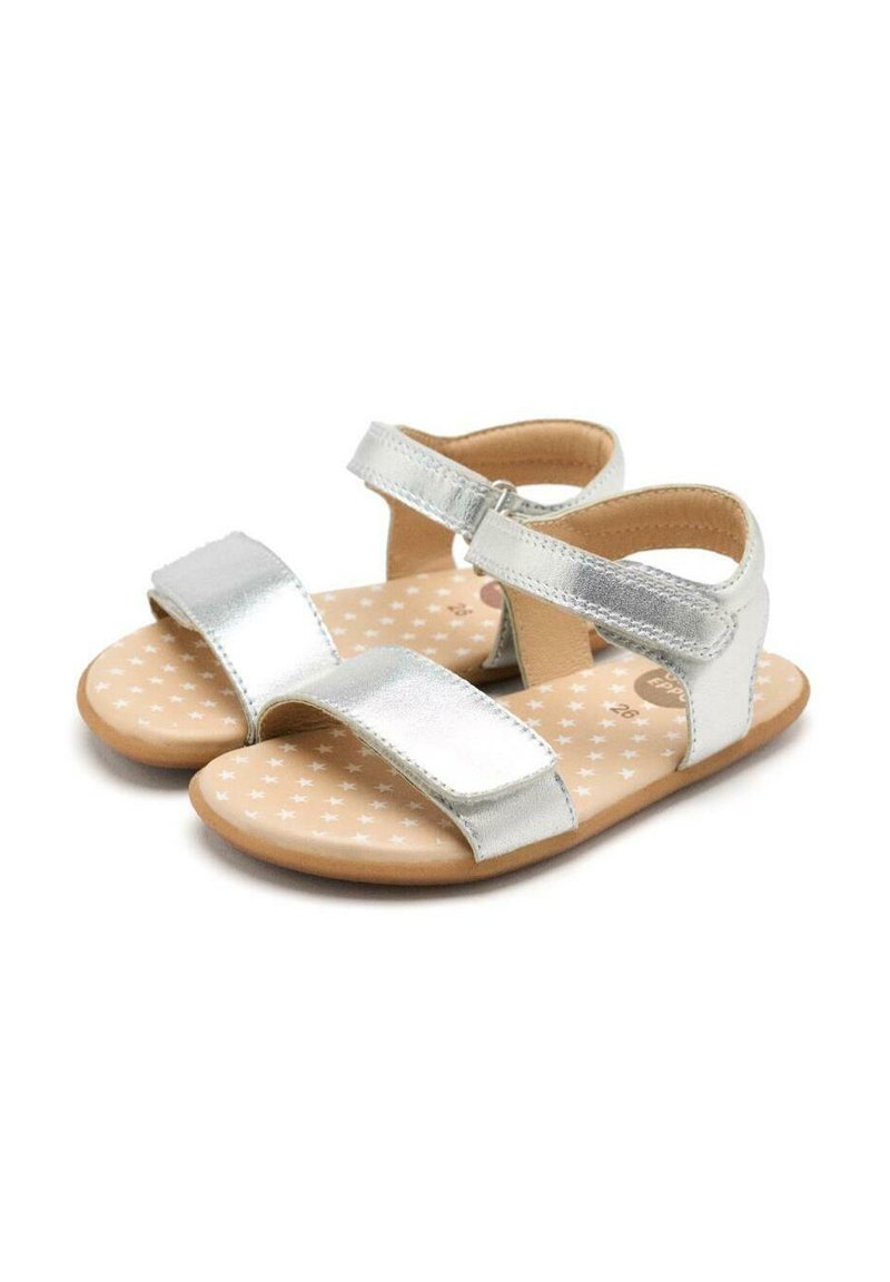 Sandalias metálicas plateadas con dos correas ajustables. La plantilla suave y estampada presenta pequeñas estrellas blancas sobre un fondo beige. Suela de goma.