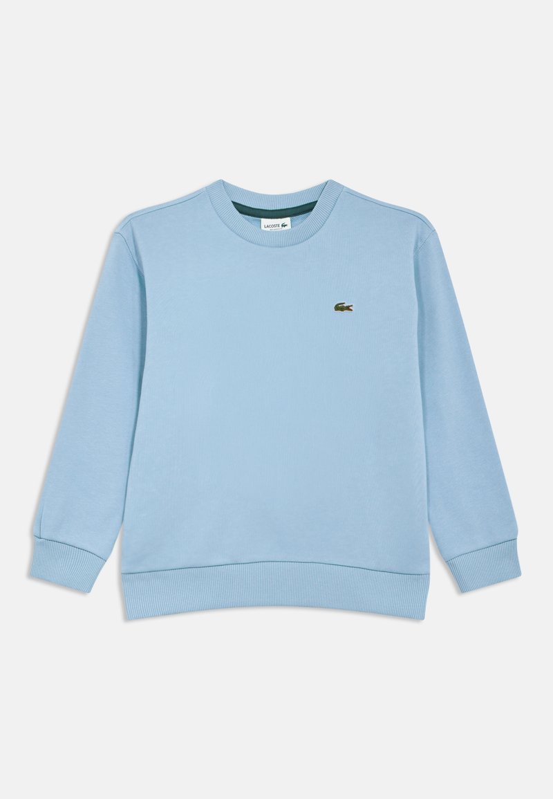Sweat-shirt bleu clair à manches longues et col rond, avec poignets et ceinture côtelés, comportant un petit logo crocodile vert brodé sur la poitrine.