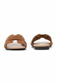 Brązowe zamszowe klapki z otwartym noskiem, płaską podeszwą i charakterystycznym wzorem wycięć na paskach.