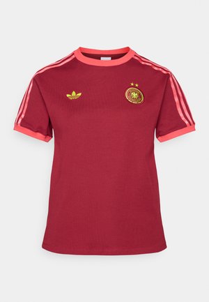 Maroon short-sleeve t-shirt made of cotton. Features pink accents on the collar and sleeves, and a yellow Adidas logo with stars and emblem.