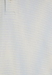 Hellblaues, strukturiertes Poloshirt mit einem dezenten Muster, Kragen und drei Knöpfen. Das Material wirkt weich und atmungsaktiv.