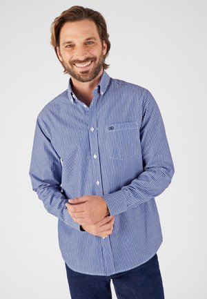 Camicia a maniche lunghe a righe blu e bianche con taschino sul petto e orlo curvo, realizzata in tessuto leggero.