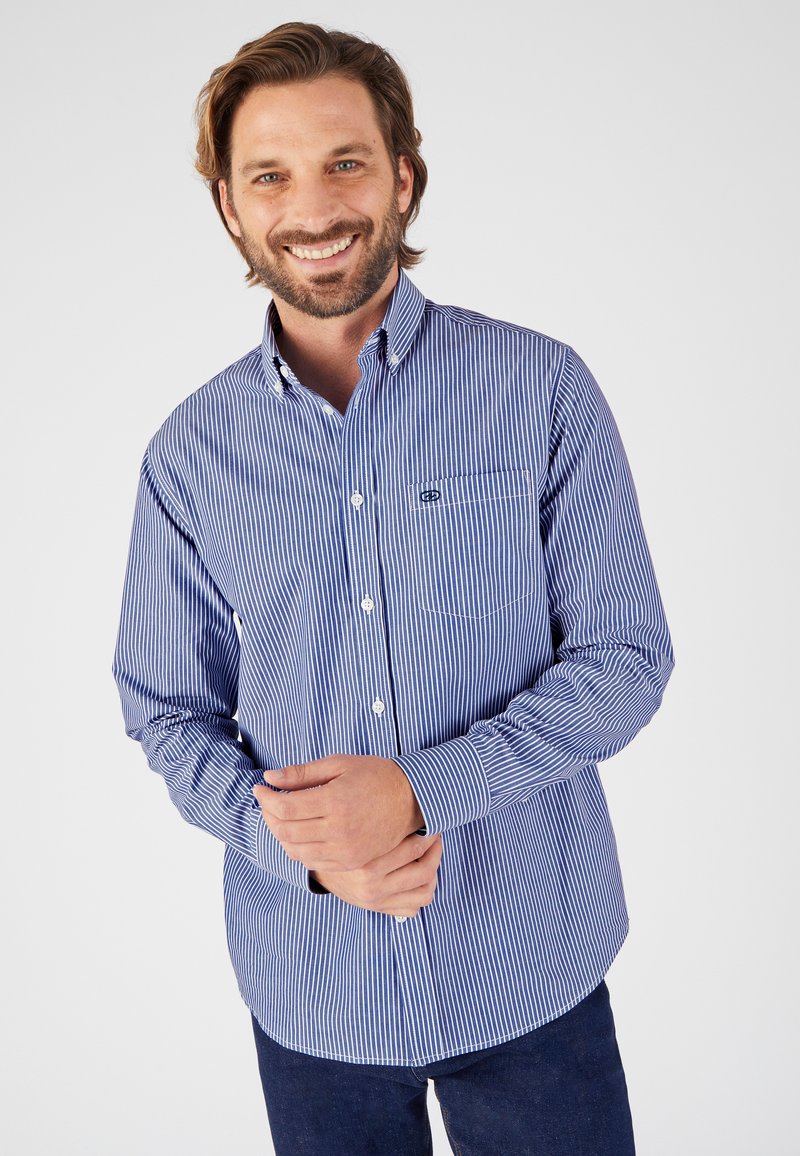 Camisa de botón de manga larga a rayas azul y blanca con un bolsillo en el pecho y dobladillo curvado, fabricada en un tejido ligero.