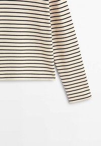 Maglia beige a maniche lunghe con strisce nere orizzontali. Realizzata in un tessuto testurizzato con orlo dritto e maniche aderenti.