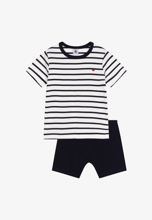 Bela in mornarsko modra črtasta srajca s kratkimi rokavi, z mornarsko modrim ovratnikom in majhnim rdečim logotipom, v kombinaciji s trdnimi mornarsko modrimi kratkimi hlačami.