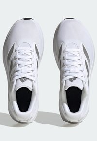 Baskets de sport blanches avec une tige en maille, fermeture à lacets et accents gris contrastants. Elles disposent d'une semelle rembourrée et d'un col rembourré.