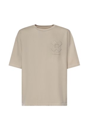 T-shirt beige in cotone a maniche corte con scollo rotondo, caratterizzata da un design a forma di stella testurizzata e dal logo "AMIRI" sul lato sinistro del petto.