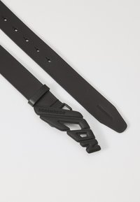 Cinturón de cuero negro con una hebilla gruesa negra con "DSQUARED2" en relieve y un diseño angular único. Textura suave, longitud ajustable.