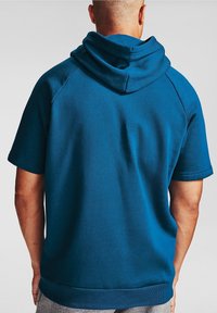 Tyrkysová mikina s ribbovaným lemem a manžetami, s velkou stylizovanou kapucí a hladkým textilním povrchem. Navržena s krátkými rukávy.