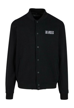 Mustern hõlmik, millel on nööpidega esikülg, kus on valge tikandiga "LOS ANGELES". Valmistatud pehmest kangast, millel on soonikkätised ja -äär.