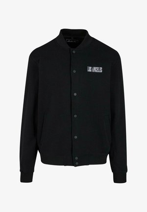 Mustern hõlmik, millel on nööpidega esikülg, kus on valge tikandiga "LOS ANGELES". Valmistatud pehmest kangast, millel on soonikkätised ja -äär.