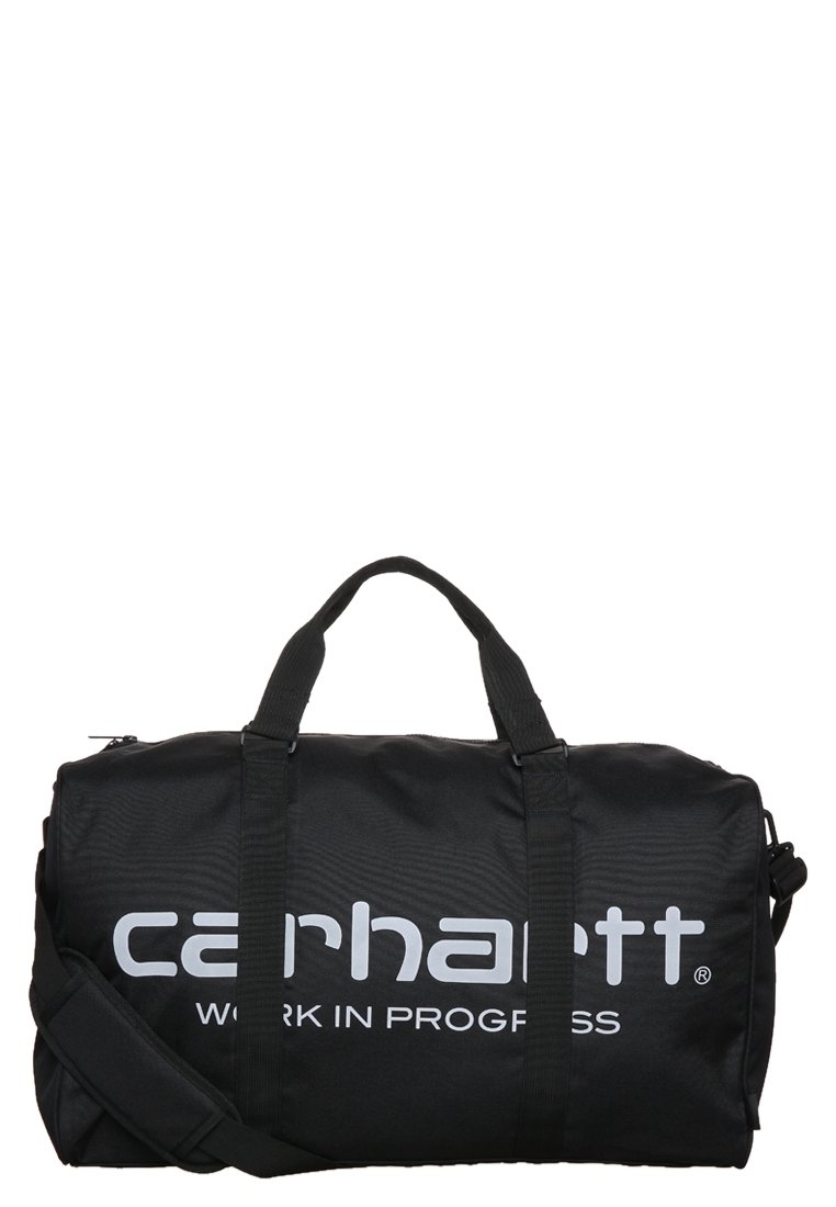 Bolsa de deporte negra hecha de tela resistente, con dos asas superiores y una correa para el hombro ajustable. Logotipo blanco prominente de "Carhartt" impreso en el lateral.