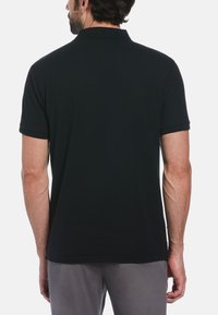 Black polo shirt with short sleeves, made of smooth fabric. Features a classic collar and a straight hem, viewed from the back.