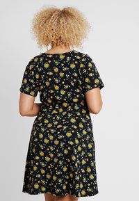 Black dress with short sleeves, featuring a floral pattern of yellow and blue flowers. Flared skirt hem and soft, textured fabric.