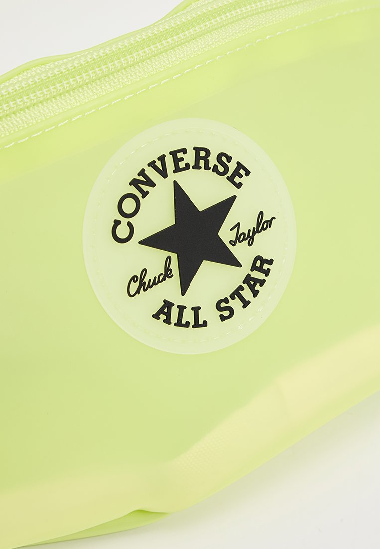 Funda translúcida verde con un acabado texturizado, con un logo de estrella negra. Cierre de cremallera en la parte superior, esquinas redondeadas y bordes suaves.