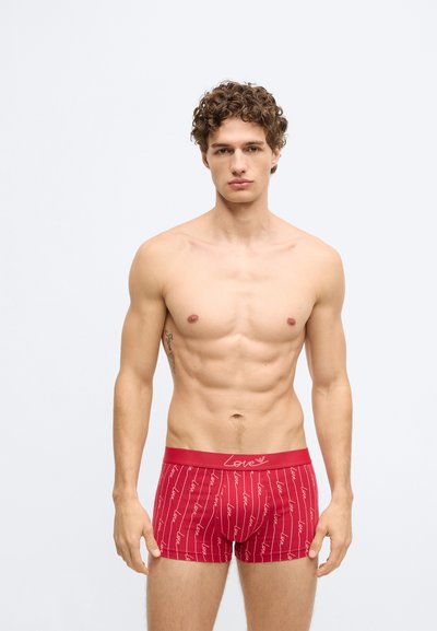 Červené boxerky s bielym pruhovým vzorom a slovom "Love" opakujúcim sa po celej ploche. Mäkká látka a pohodlný pás s dizajnom pre komfort.