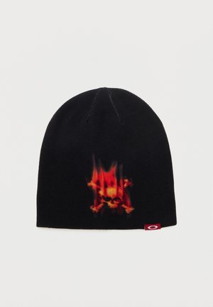 Bonnet en maille noire avec un motif de flamme rouge et orange et un crâne sur le devant, ainsi qu'une petite étiquette rouge sur le bord.