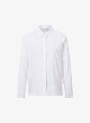 Valge pikkade varrukatega särk, mis on valmistatud siledast puuvillast. Omab teravat kraed ja ees nuppe sulgemiseks. Lihtne, kaunistusteta disain otsekohese lõikega.