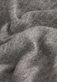 Texturovaná tkanina s tlumenou hnědou a šedou barevnou paletou, která ukazuje měkký, tkaný vzhled s jemnými variacemi odstínu.