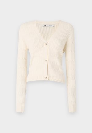 Cardigan en tricot de couleur crème avec un col en V, des manches longues et des accents de boutons en forme de cœur. Possède un motif côtelé texturé et un design court.