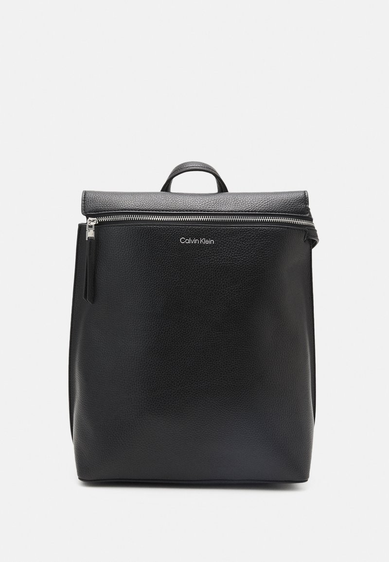 Czarny skórzany plecak o teksturowanym wykończeniu, z zamkiem błyskawicznym i uchwytem u góry. Posiada detal z logo z przodu oraz minimalistyczny design.