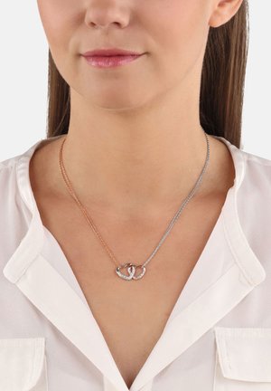 Collana in oro rosa e argento con cuori intrecciati, caratterizzata da un design texturizzato e piccole pietre trasparenti incastonate in uno dei cuori.
