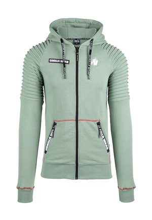 Green zip-up hoodie with ribbed shoulder detailing, black zipper, and pockets featuring red accents. Logo displayed on the chest area.