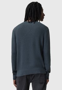 Maglione a maglia testurizzata di colore blu scuro, con scollatura rotonda e maniche lunghe, dotato di orlo e polsini a coste, progettato per un fit rilassato.