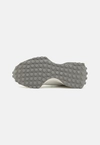 Schuhsohle mit einer strukturierten, grauen Gummibeschichtung, die runde Dellen für besseren Halt aufweist. Sie verfügt über eine abgerundete Kante und eine glatte Innenauskleidung.