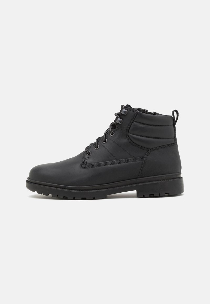 Botas de cuero negras con suela robusta, que cuentan con un diseño de cordones, soporte acolchado en el tobillo y una pestaña trasera para facilitar el calzado.