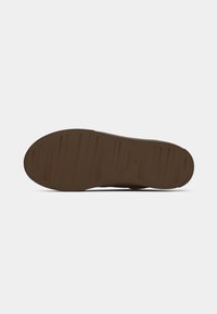Brown rubber shoe sole with textured pattern, featuring horizontal grooves and a rounded toe. Marked with a brand logo and size 35.
