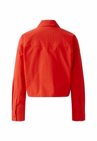 Chemise courte rouge vif à manches longues avec poignets boutonnés et col, vue de dos sur fond blanc.