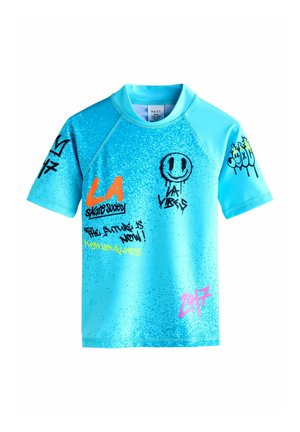 Blue short-sleeve shirt made of smooth material. Features graffiti-style graphics in orange, black, and pink with varied textures and designs.