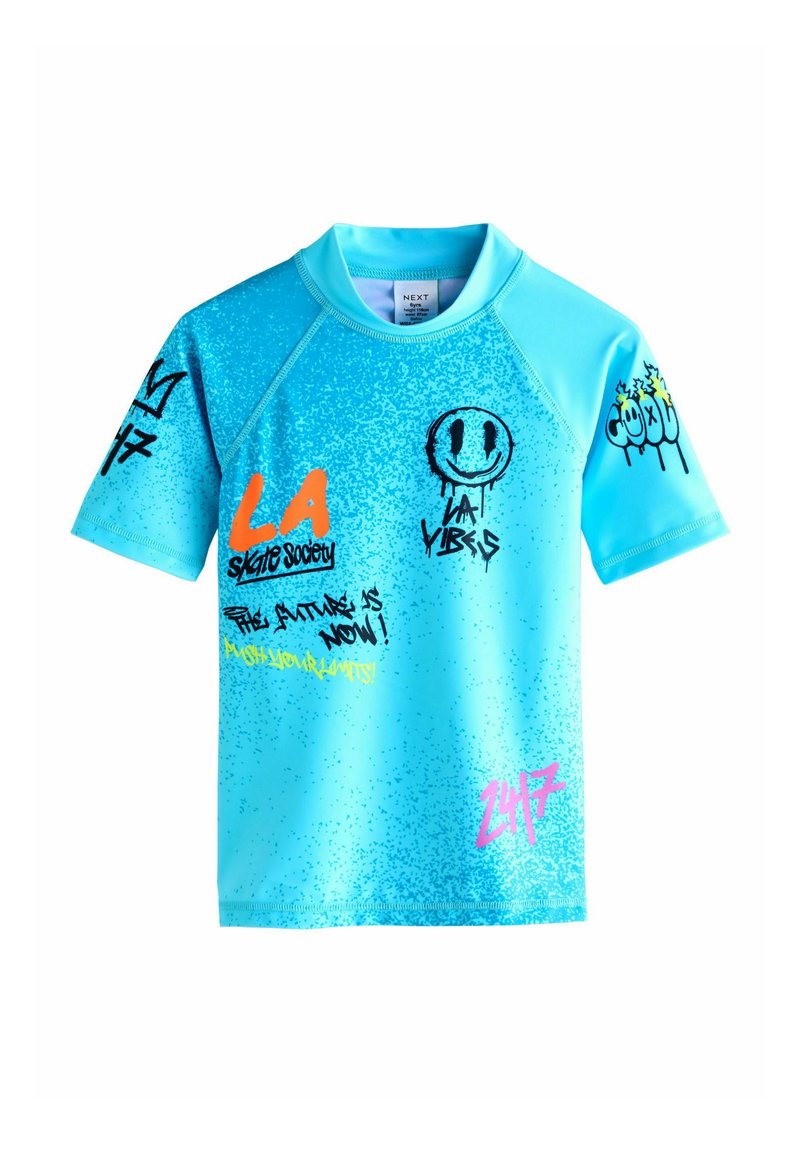 Camicia azzurra a maniche corte in materiale liscio. Presenta grafiche in stile graffiti in arancione, nero e rosa con texture e design vari.