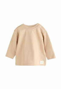 Camicia beige a maniche lunghe in morbido tessuto con colletto rotondo e due bottoni a pressione sulla spalla. Presenta un piccolo etichetta sull'orlo.