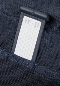 Marineblauer Stoff mit gewebter Textur, der einen transparenten Plastik-Ausweisinhaber enthält, der leere Zeilen für persönliche Informationen anzeigt.