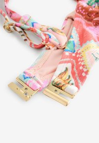 Színes szövetpántok virágos és absztrakt mintákkal. Arany fém csatok a végeken. Puha, texturált anyag.