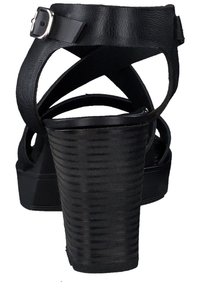 Svart högklackad sandal med en strukturerad plattform, justerbar ankelrem och korsade läderband vid tåområdet.