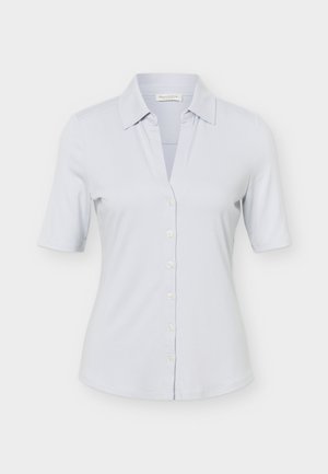 Camicia azzurro chiaro a maniche corte con bottoni, collo appuntito e vita aderente, esposta su sfondo bianco.