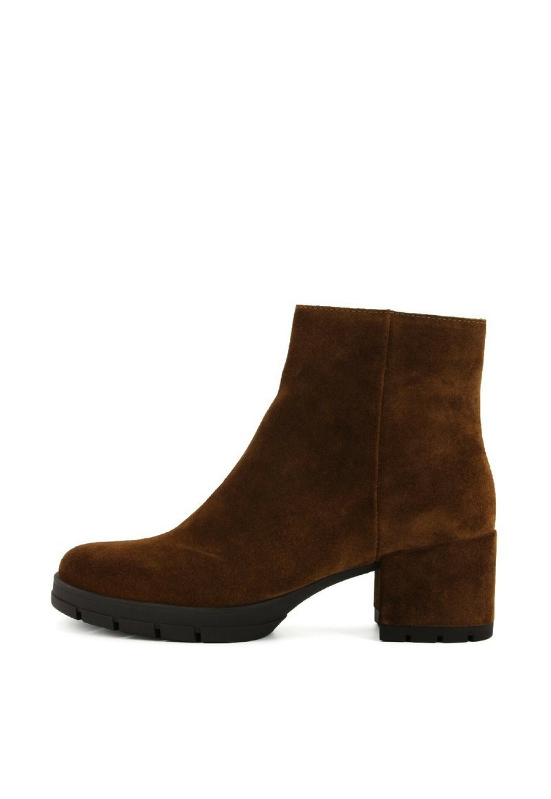 Stivale alla caviglia in suede marrone con tacco a blocco, punta rotonda, texture liscia e design minimalista. Suola in gomma per aderenza e durata.