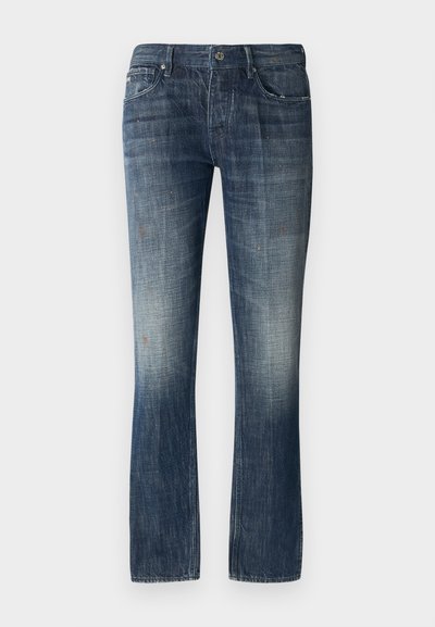 Tamsiai mėlynos džinsinės kelnes su išblukusia priekiu ir šviesiu dilimu. Tiesus siluetas, su juosmeniu ir penkiais kišenėmis. Sidabriniai detalių akcentai.