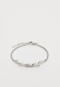 Silver chain bracelet featuring crocodile-shaped links with textured detailing. Clasp closure at one end, minimalist design overall.