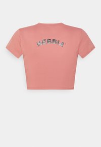Kortærmet cropped t-shirt i blødt lyserødt stof. Har en rund halsudskæring og et metallic tryk af "NEBBIA" på ryggen.