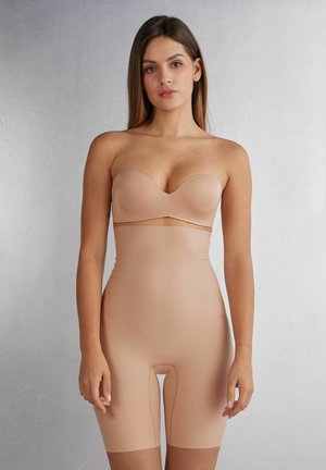 Nude seamless bodysuit with a strapless, sweetheart neckline and mid-thigh length, made from smooth, stretchy material with no visible seams.